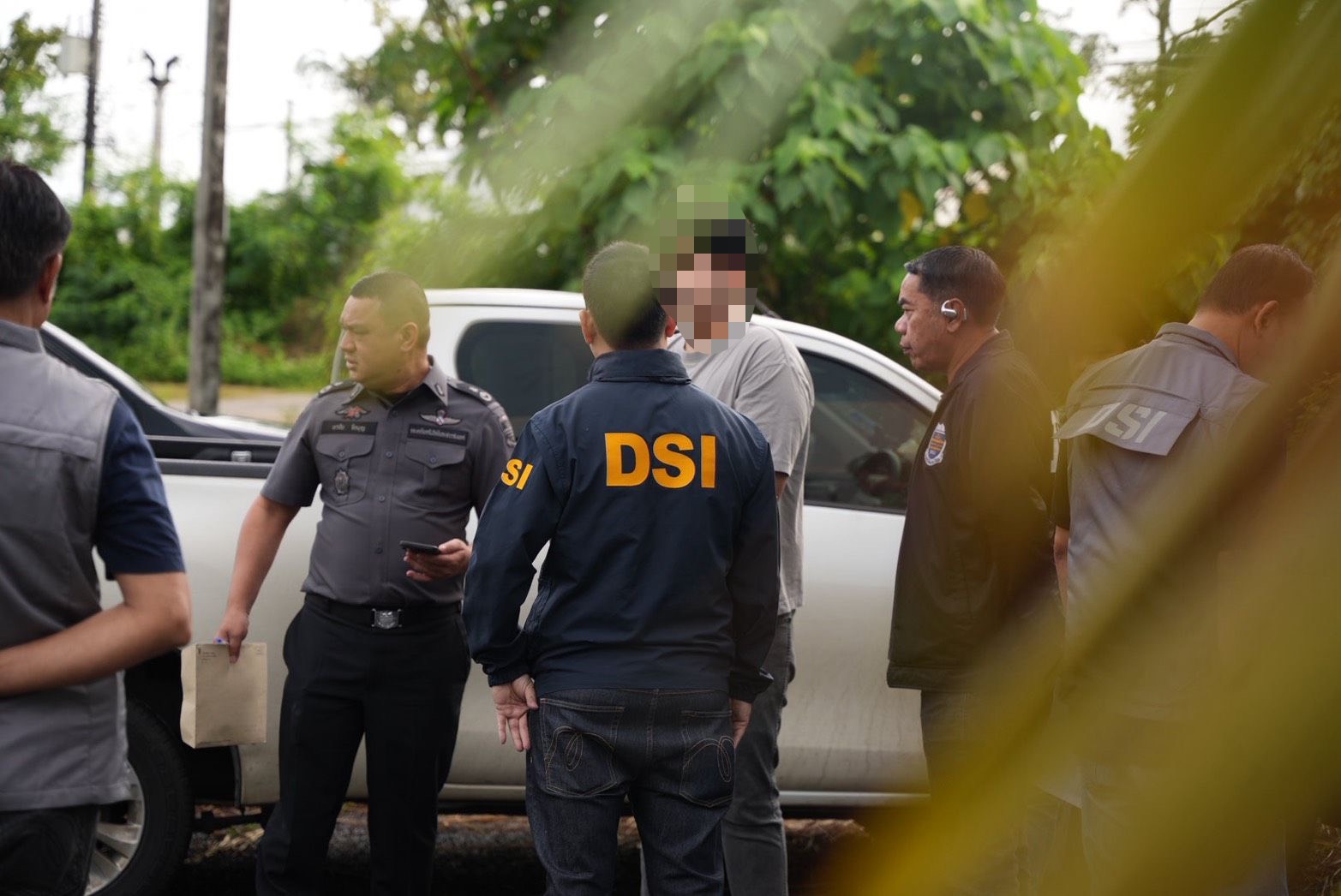 Law enforcement officers working beside a vehicle